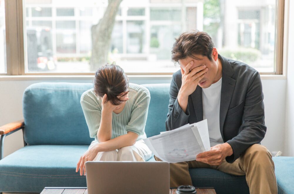 書面を見て頭を抱える夫婦