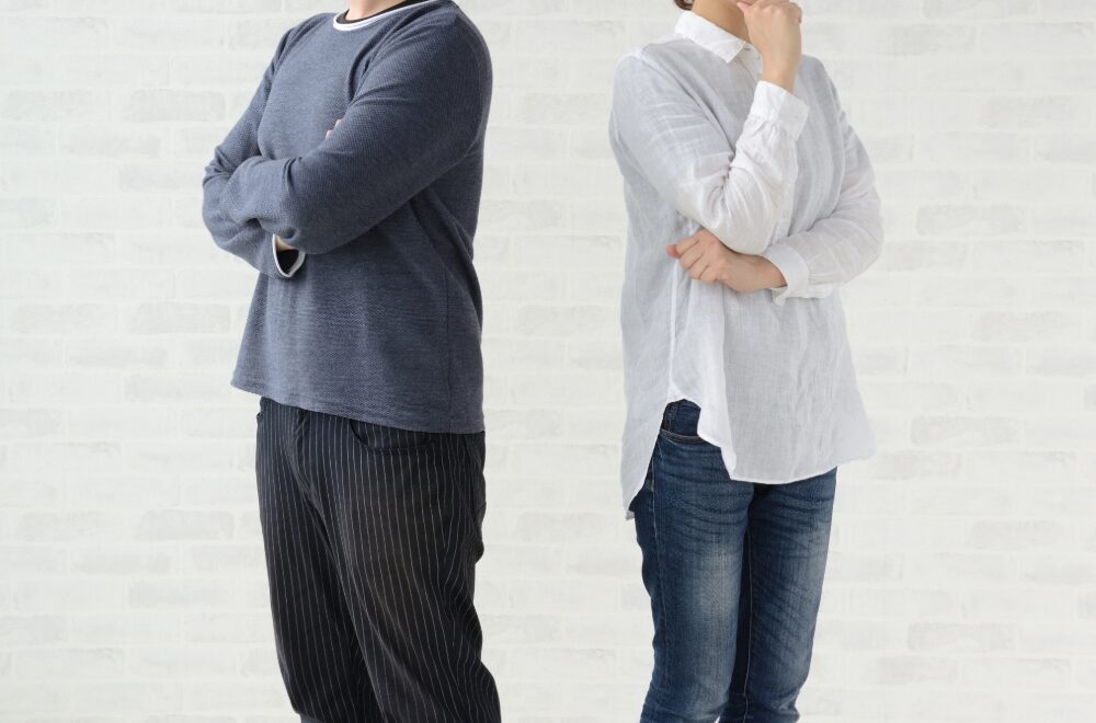 背を向けて悩んでいる男性と女性