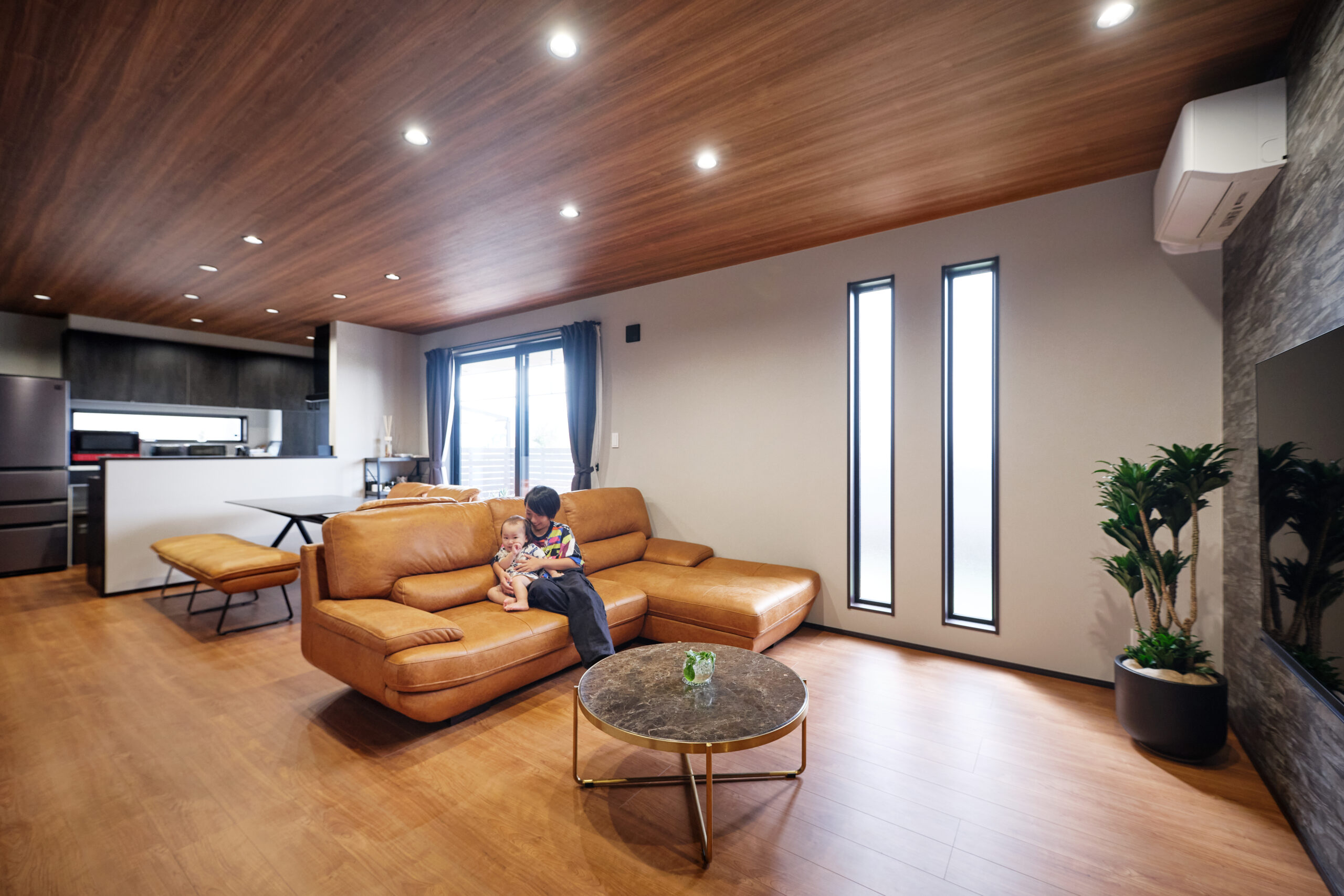 ウッド調のLDK空間と室内で遊ぶ子どもたち（アイラックホーム施工事例）